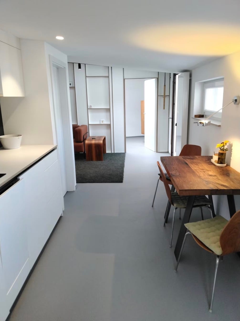 Blick durch die Ferienwohnung: offene Küche links, Esstisch rechts, im Hintergrund der Wohnbereich